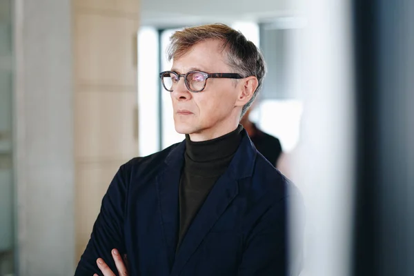 Portrait of  confident businessman standing in new office. Mature CEO posing indoors. 免版税图库照片