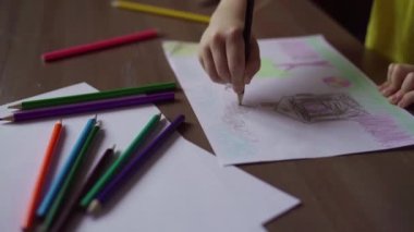 Çocuk kalem kağıt üzerinde çizer.