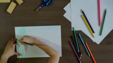 Çocuk kalem kağıt üzerinde çizer.