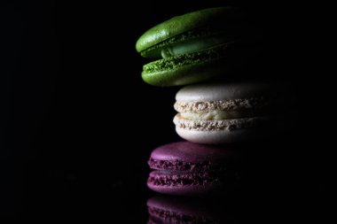 Siyah arka planda parlak renkli badem kurabiyeleri.