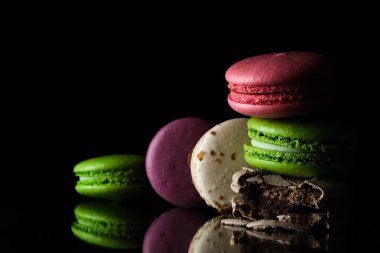 Siyah arka planda parlak renkli badem kurabiyeleri.