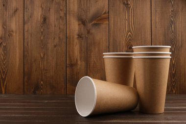 Ahşap bir arka planda altı tane çevre dostu bardak var. Ekoloji kavramı. Model-up. Boşluğu kopyala