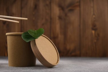 Yeşil yapraklı ve çubuklu mukavva çorba kabı ahşap arka planda ekolojinin motive edici bir kavramıdır. Model-up. Uzayı kopyala Ekoloji kavramı.