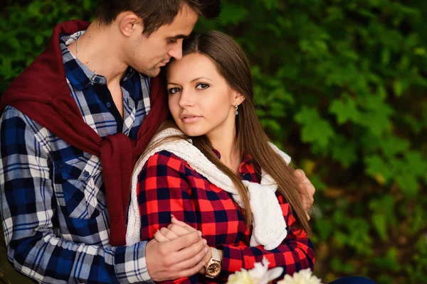 Elegante giovane coppia in camicie e jeans mentre passeggia nel bosco. Una bella ragazza con il suo bel ragazzo in un abbraccio s. Close up portrait . — Foto Stock