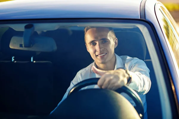 Atraente bonito bem sucedido homem no branco camisa dirigindo um caro carro — Fotografia de Stock