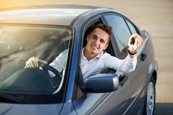 Comprador feliz segurando chaves do carro dentro de seu novo veículo — Fotografia de Stock