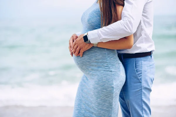 Close up of loving couple touching with love and care a pregnant belly with their hands. — Stock Photo, Image