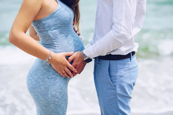 Primer plano de pareja cariñosa tocando con amor y cuidado de un vientre embarazada con sus manos . —  Fotos de Stock