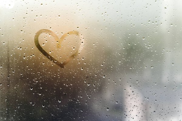 Rainy weather, the inscription heart on the sweaty glass.