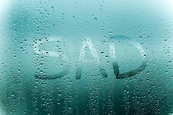 Deszczowa pogoda, napis smutny na szybie spocony. — Zdjęcie stockowe