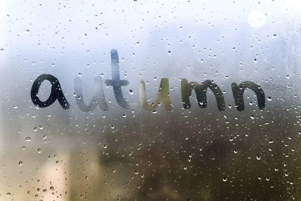 Regenwetter, der Schriftzug Herbst auf dem schweißtreibenden Glas. — Stockfoto