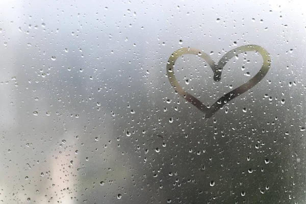 Deszczowa pogoda, serce napis na szybie spocony. — Zdjęcie stockowe