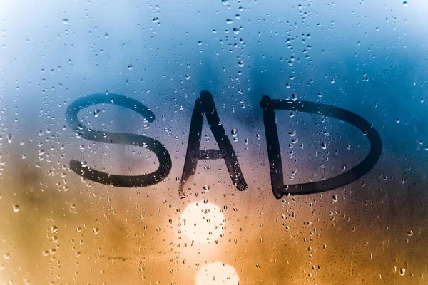 Rainy weather, the inscription sad on the sweaty glass. — Stock Photo, Image