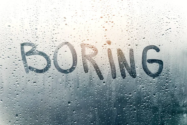 Rainy weather, the inscription boring on the sweaty glass. Steamy glass. — Stock Photo, Image