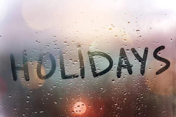 Rainy weather, the inscription holidays on the sweaty glass. — Stock Photo, Image