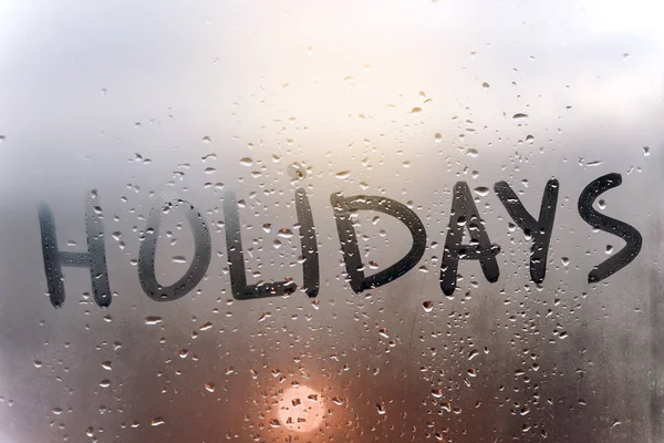 Rainy weather, the inscription holidays on the sweaty glass. — Stock Photo, Image