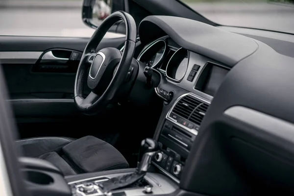 Luxury car interior. Steering wheel, shift lever and dashboard.