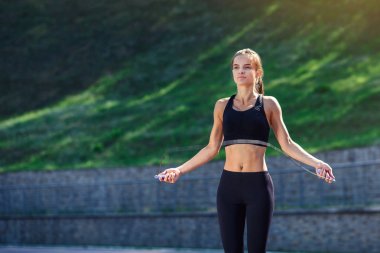 Sporcu kadın Stadyumu'nda ip atlama ile atlama. Aktif fitness erkek açık yapıyor. Fitness kavramı. Sağlıklı yaşam tarzı.