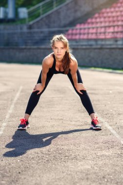 Fitness kız sadium daha önce eğitim germe yapıyor. Fitness kadın atlet sıcak önce onun gücü eğitim kardiyo egzersiz yapıyor.