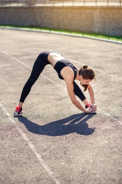 Fitness kız sadium daha önce eğitim germe yapıyor. Fitness kadın atlet sıcak önce onun gücü eğitim kardiyo egzersiz yapıyor.