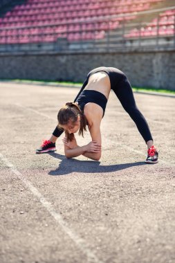 Fitness kız sadium daha önce eğitim germe yapıyor. Fitness kadın atlet sıcak önce onun gücü eğitim kardiyo egzersiz yapıyor.