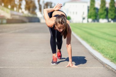 Gitmek için hazır! Kadın atlet başlangıç çizgisine Stadyumu parçanın üzerinde bir çalıştırmak için hazırlanıyor. Fitness kız düşük bir başlangıç çalıştırmak hazırlanıyor. Sağlıklı yaşam tarzı.