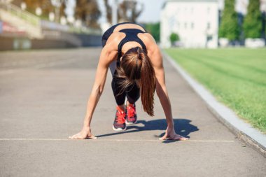 Gitmek için hazır! Kadın atlet başlangıç çizgisine Stadyumu parçanın üzerinde bir çalıştırmak için hazırlanıyor. Fitness kız düşük bir başlangıç çalıştırmak hazırlanıyor. Sağlıklı yaşam tarzı.