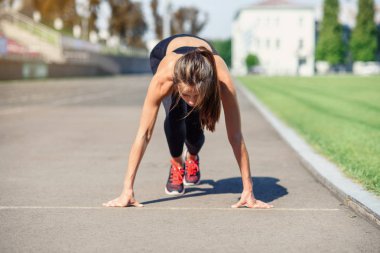 Gitmek için hazır! Kadın atlet başlangıç çizgisine Stadyumu parçanın üzerinde bir çalıştırmak için hazırlanıyor. Fitness kız düşük bir başlangıç çalıştırmak hazırlanıyor. Sağlıklı yaşam tarzı.