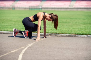 Gitmek için hazır! Kadın atlet başlangıç çizgisine Stadyumu parçanın üzerinde bir çalıştırmak için hazırlanıyor. Fitness kız düşük bir başlangıç çalıştırmak hazırlanıyor. Sağlıklı yaşam tarzı.