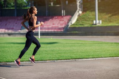 Bir stadyum yolda çalışan genç fitness kadın. Sporcu kız Stadyumu'nda eğitim egzersizleri yapıyor. Sağlıklı aktif yaşam tarzı.