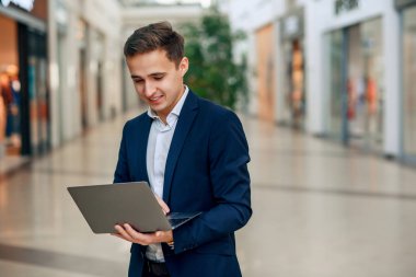 Dizüstü bilgisayarda çalışma başarılı genç iş adamı. Takım elbiseli şık yakışıklı adam. Forex cryptocurrency ticaret, işletme kavramı.