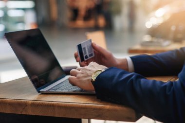 Kredi kartı numaraları, ahşap masa, seçici odak kafede otururken bilgisayar klavyede yazmaya tutan erkek el. Bankacılık web ve uluslararası ağ ödeme. Online alışveriş, e ticaret, kredi kartı ödeme kavramı.