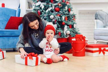 Annesiyle birlikte tatil hediyelerini açan sevimli bir çocuk..