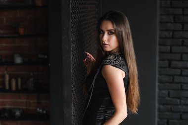 Metal şebekenin yanında seksi deri elbiseli şık bir kız..