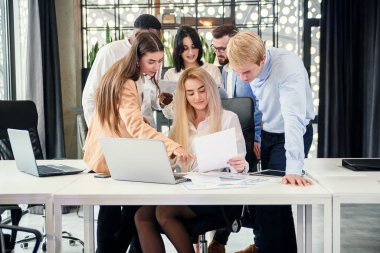 Yönetim kurulu masasındaki ortak proje kapsamında yapılan çalışmalar sırasında finansal raporları analiz eden başarılı bir genç ırk çalışma takımı. İş ve mali konsept.