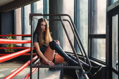 Deri şort ve ceket giyen çekici manken boks ringinde poz veriyor..