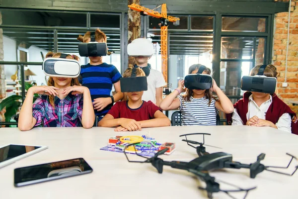 Modern technologies in a smart school. Clever caucasian pupils use virtual reality glasses for education. — Stock Photo, Image