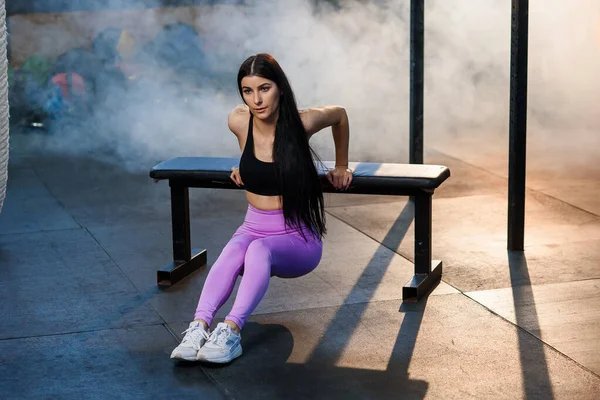 Jovem mulher esporte fazendo exercício usando banco no ginásio . — Fotografia de Stock