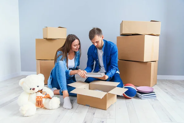 Young couple unpacking things after moving into new house — Stock Photo, Image