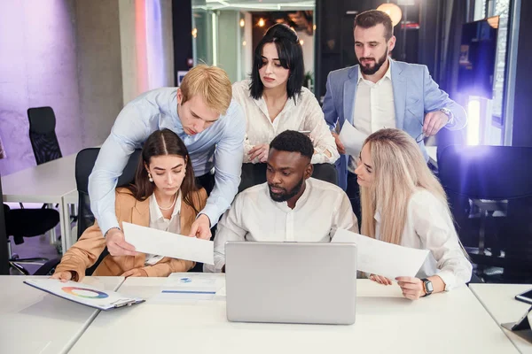 Atractivos gerentes de oficinas multirraciales discutiendo su plan de negocios en el ordenador personal y analizando temas . — Foto de Stock