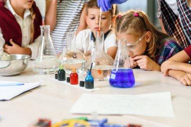 Renkli sıvı maddelerle test tüpleri. Sıvı durumları inceleyin. Test tüplü grup öğrencileri kimyasal sıvılar üzerinde çalışıyorlar. Bilim konsepti. Kızlar ve erkek sıvı deneyi yapıyorlar..