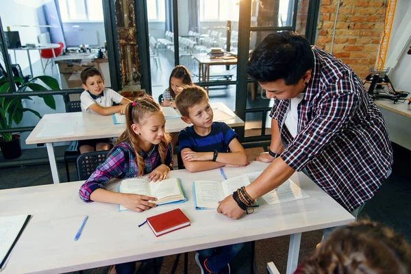 Profesor masculino explica tarea de lección para el alumno en el aula . — Foto de Stock