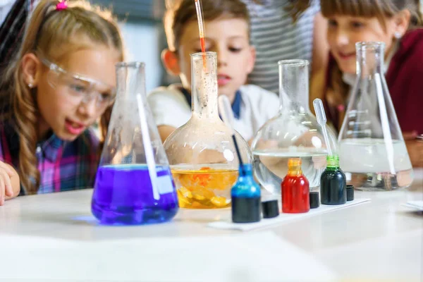 Renkli sıvı maddelerle test tüpleri. Sıvı durumları inceleyin. Test tüplü grup öğrencileri kimyasal sıvılar üzerinde çalışıyorlar. Bilim konsepti. Kızlar ve erkek sıvı deneyi yapıyorlar.. — Stok fotoğraf