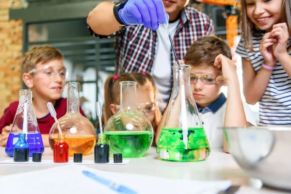 Renkli sıvı maddelerle test tüpleri. Sıvı durumları inceleyin. Test tüplü grup öğrencileri kimyasal sıvılar üzerinde çalışıyorlar. Bilim konsepti. Kızlar ve erkek sıvı deneyi yapıyorlar.. — Stok fotoğraf