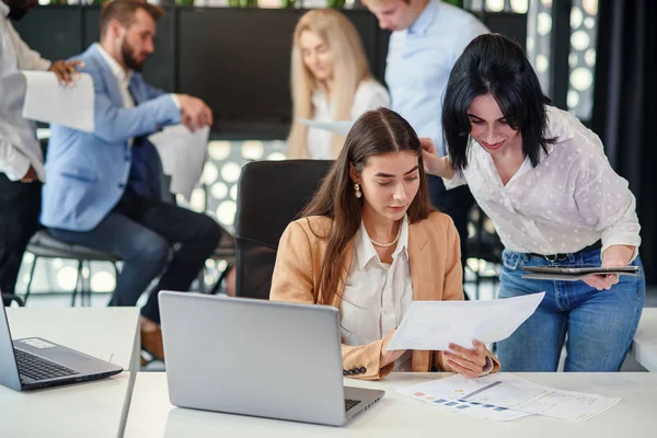 Atractiva trabajadora consultando con su gerente de oficina y firmando un documento financiero en su lugar de trabajo . — Foto de Stock