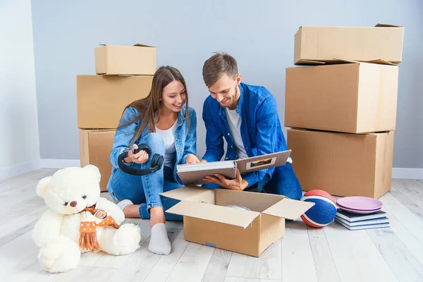 Young couple unpacking things after moving into new house — Stock Photo, Image