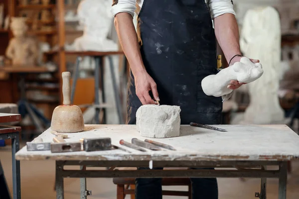 Mani maschili che lavorano con una pietra bianca. Scultore professionista intaglia scultura in pietra da calcare . — Foto Stock