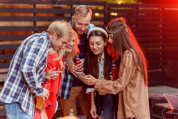 Grupo de jóvenes amigos felices disfrutando del fin de semana en la fiesta usando un teléfono inteligente compartiendo foto selfie en las redes sociales . — Foto de Stock