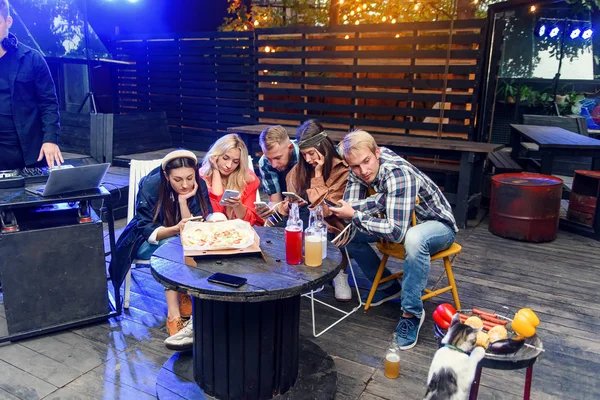 Amigos olhando para seus smartphones em uma festa chata. Conceitos de tecnologia e problemas de estilo de vida moderno . — Fotografia de Stock