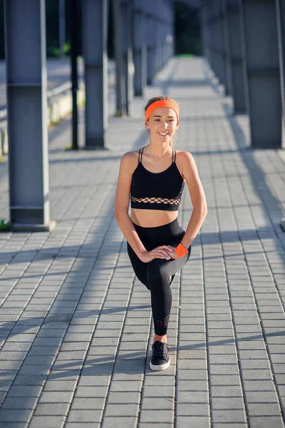 Hermosa chica deportiva haciendo ejercicios de calentamiento matutino al aire libre . — Foto de Stock